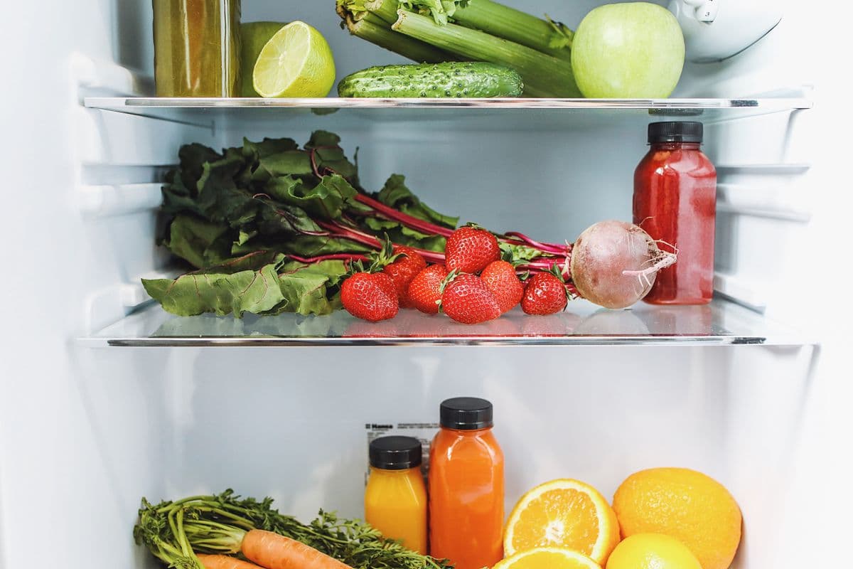 Arranjo colorido de frutas e vegetais frescos organizados de forma organizada na geladeira