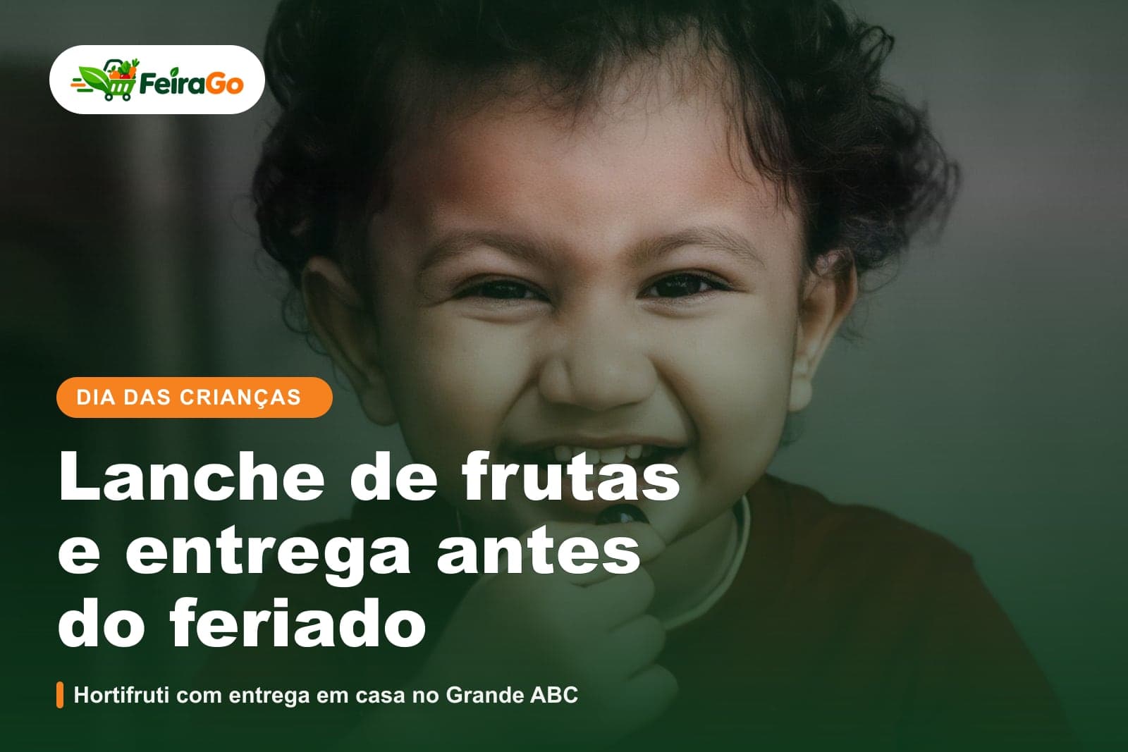 Criança de cabelos cacheados sorrindo e comendo uma fruta, usando uma camiseta vermelha