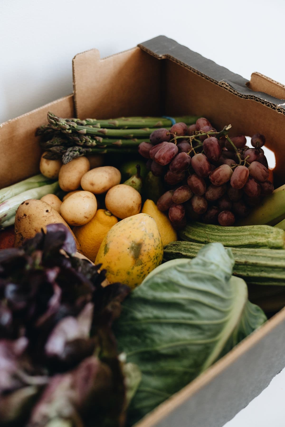 Caixa de papelão cheia de frutas e vegetais frescos e coloridos