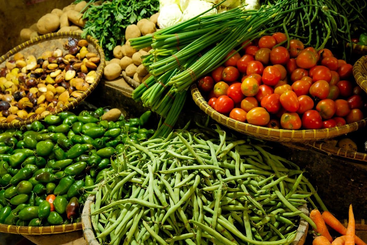 Barraca de feira com grande variedade de vegetais frescos e coloridos