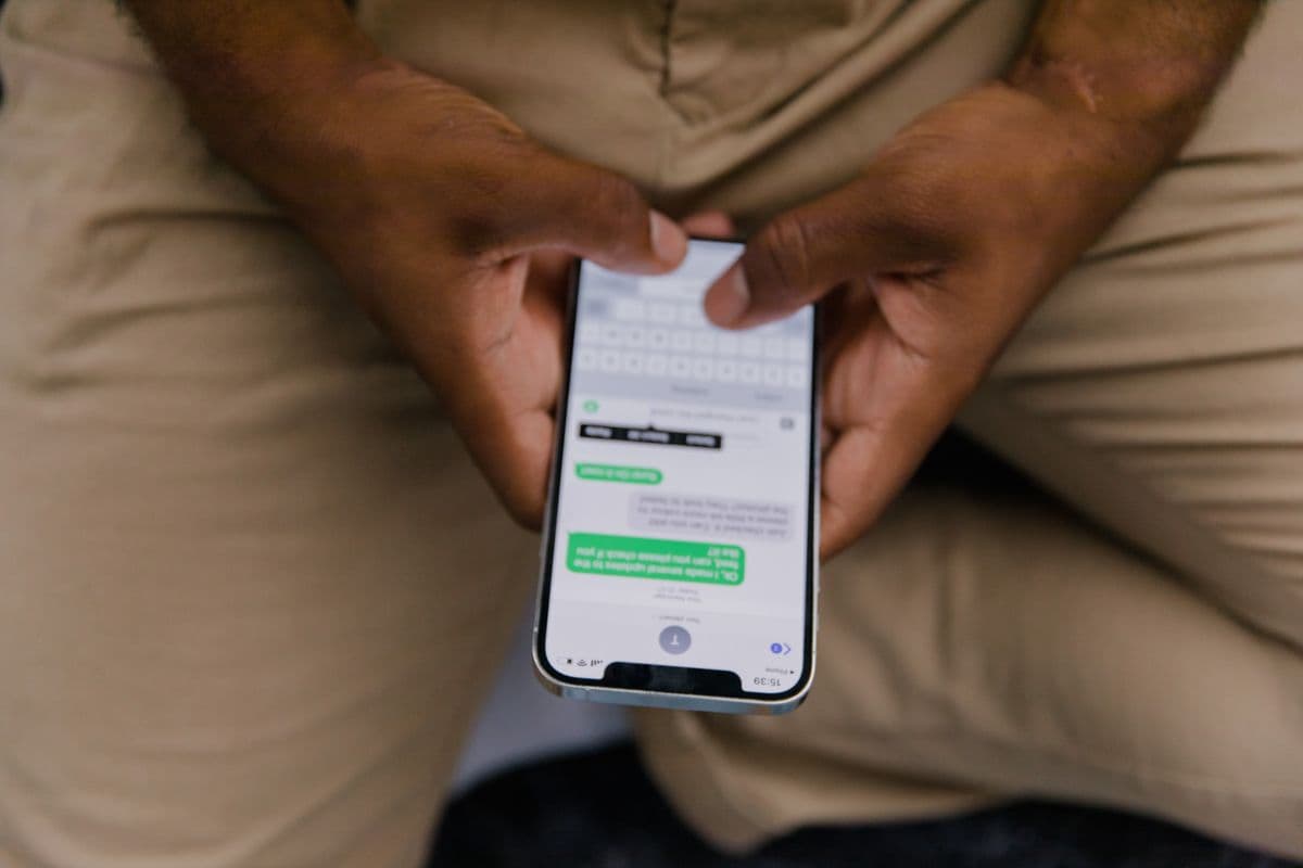 Pessoa digitando em um celular com as duas mãos