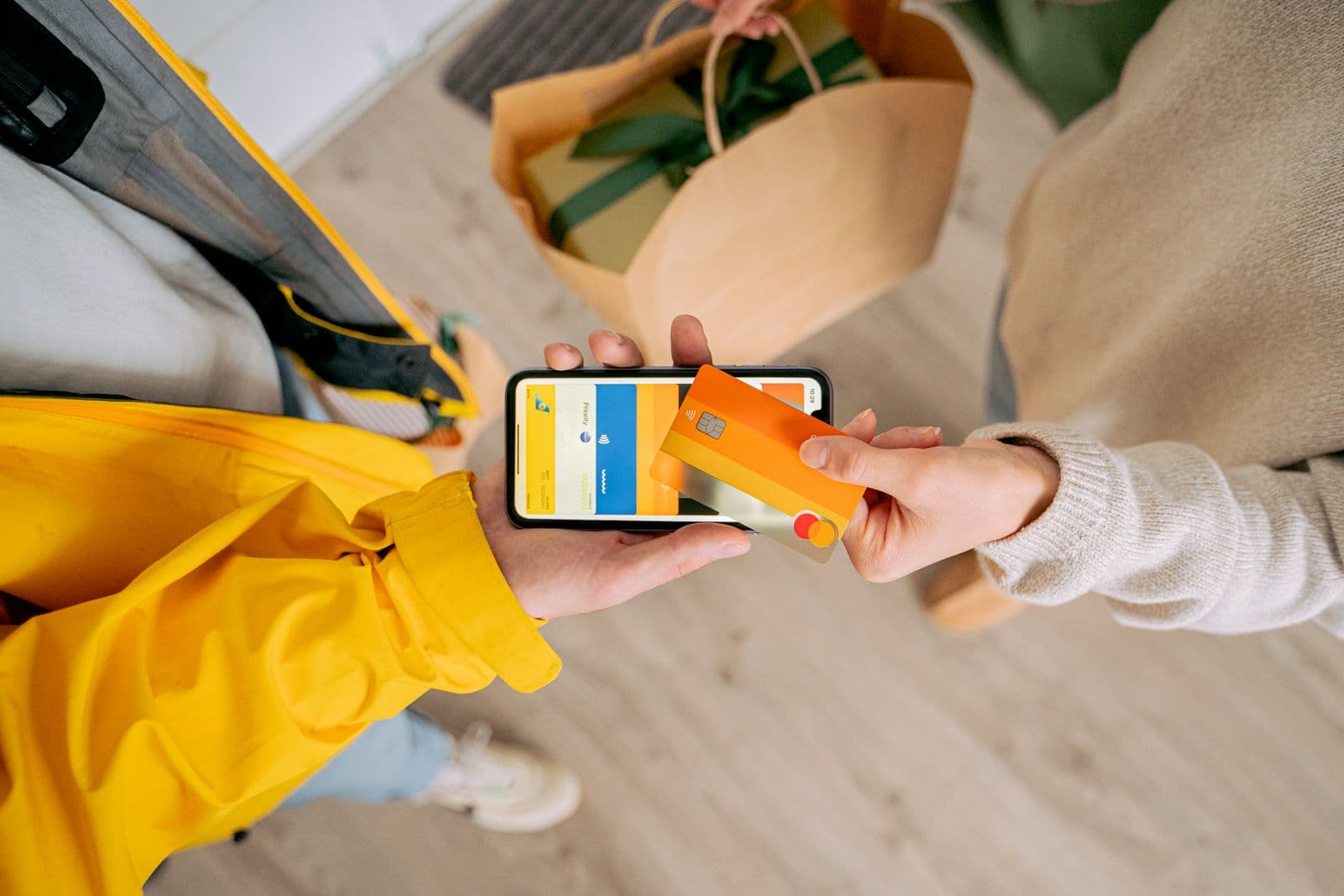 Pessoa fazendo pagamento por aproximação com o celular ao retirar uma sacola de compras