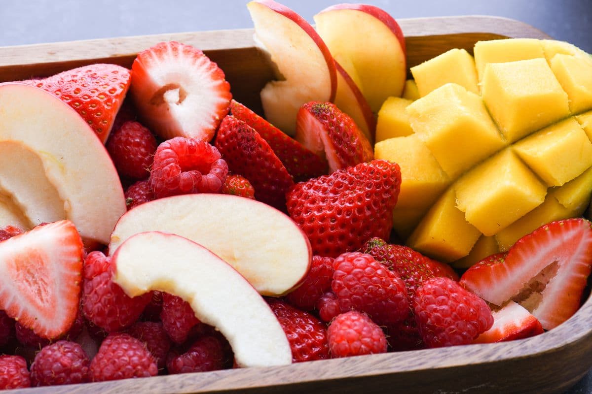 Frutas fatiadas de maçã, morango e manga em close