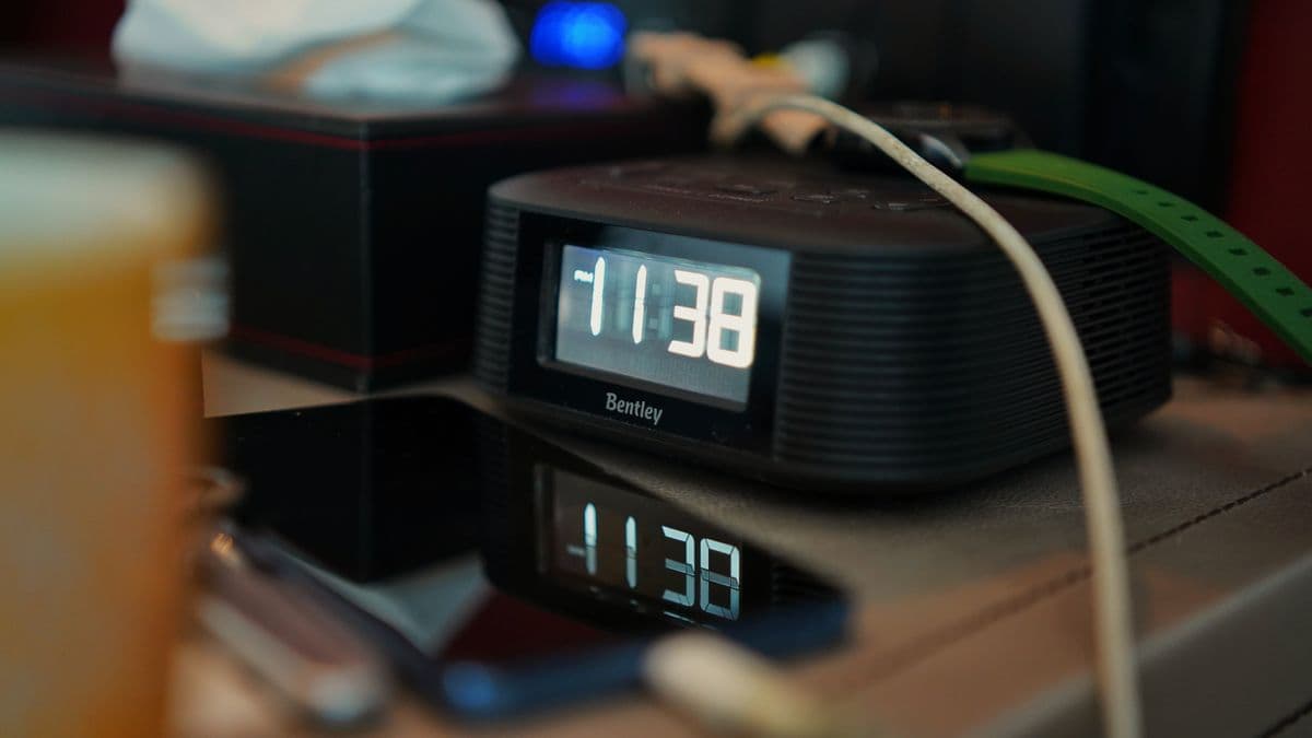 Relógio digital marcando 11:38 ao lado de um celular