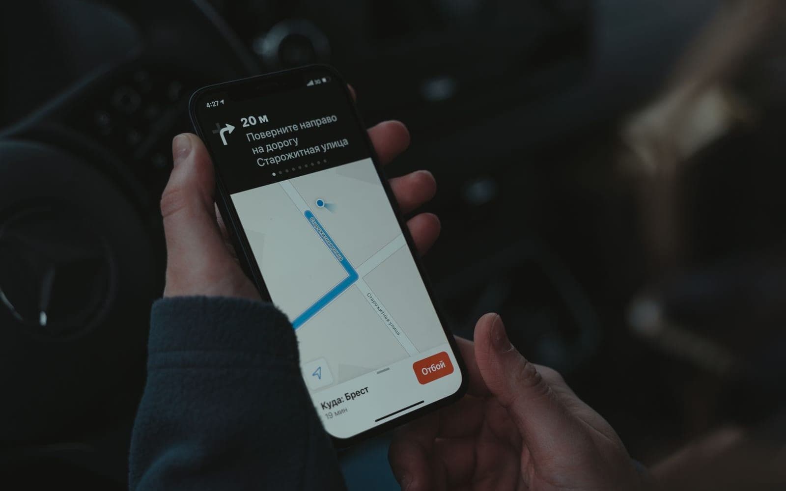Mãos segurando um celular com um aplicativo de rotas aberto no mapa