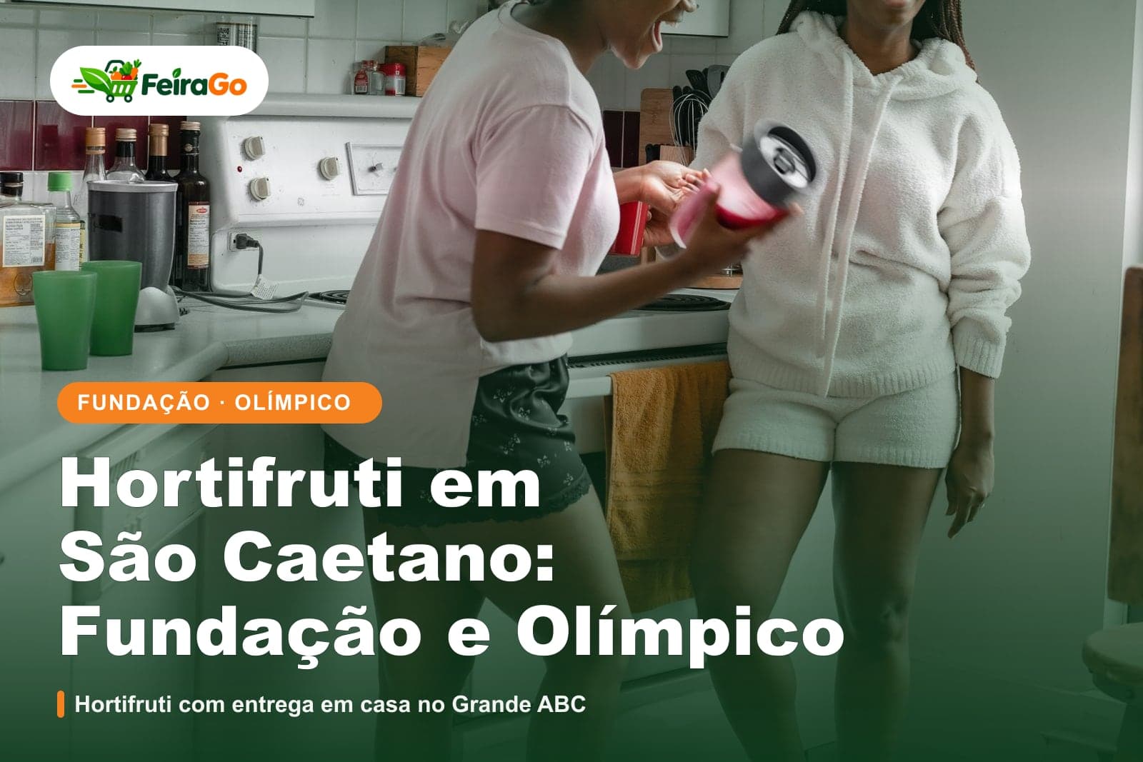 Duas mulheres riem juntas em uma cozinha, uma delas segurando um copo