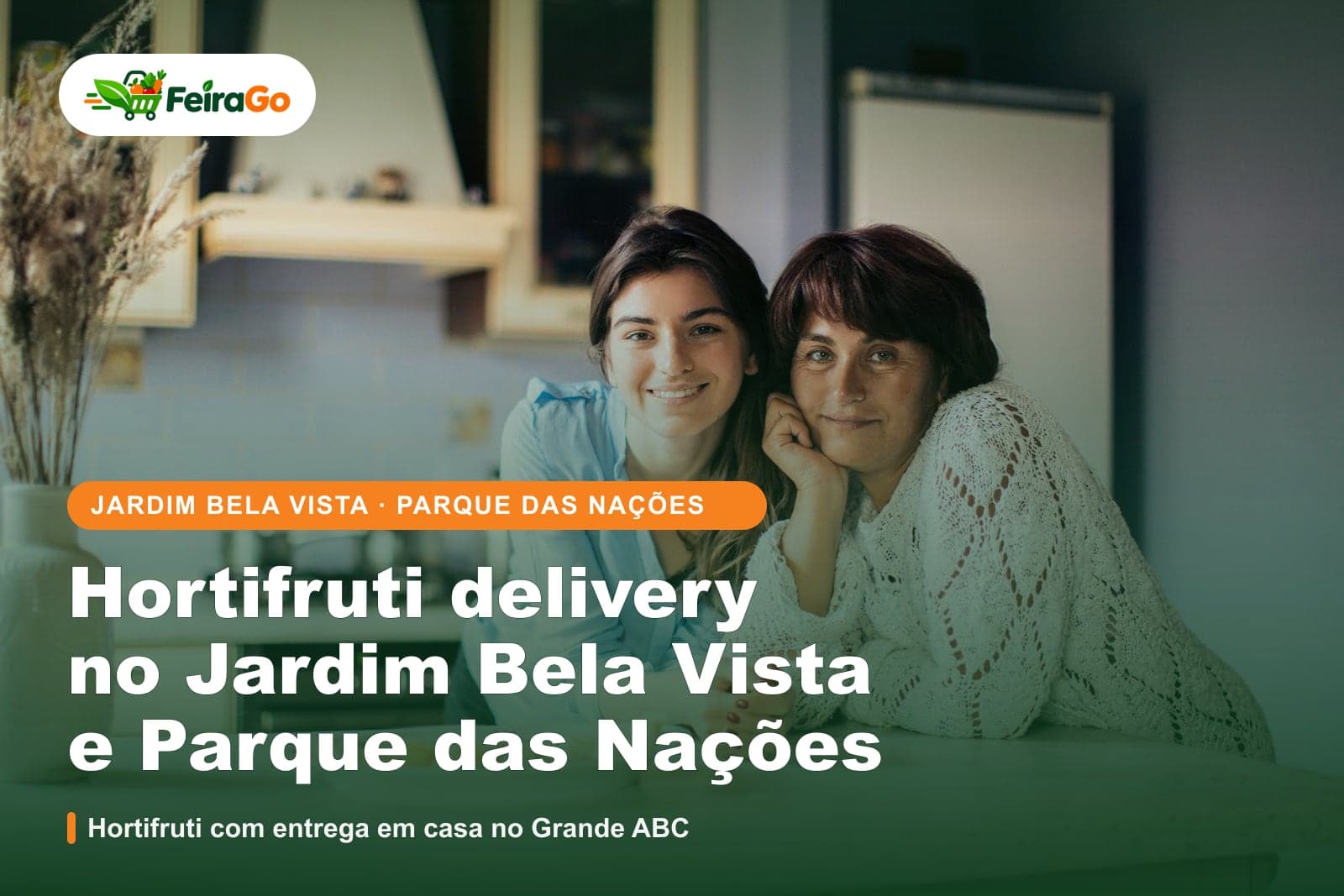 Duas mulheres sorridentes posam lado a lado em uma cozinha clara de casa