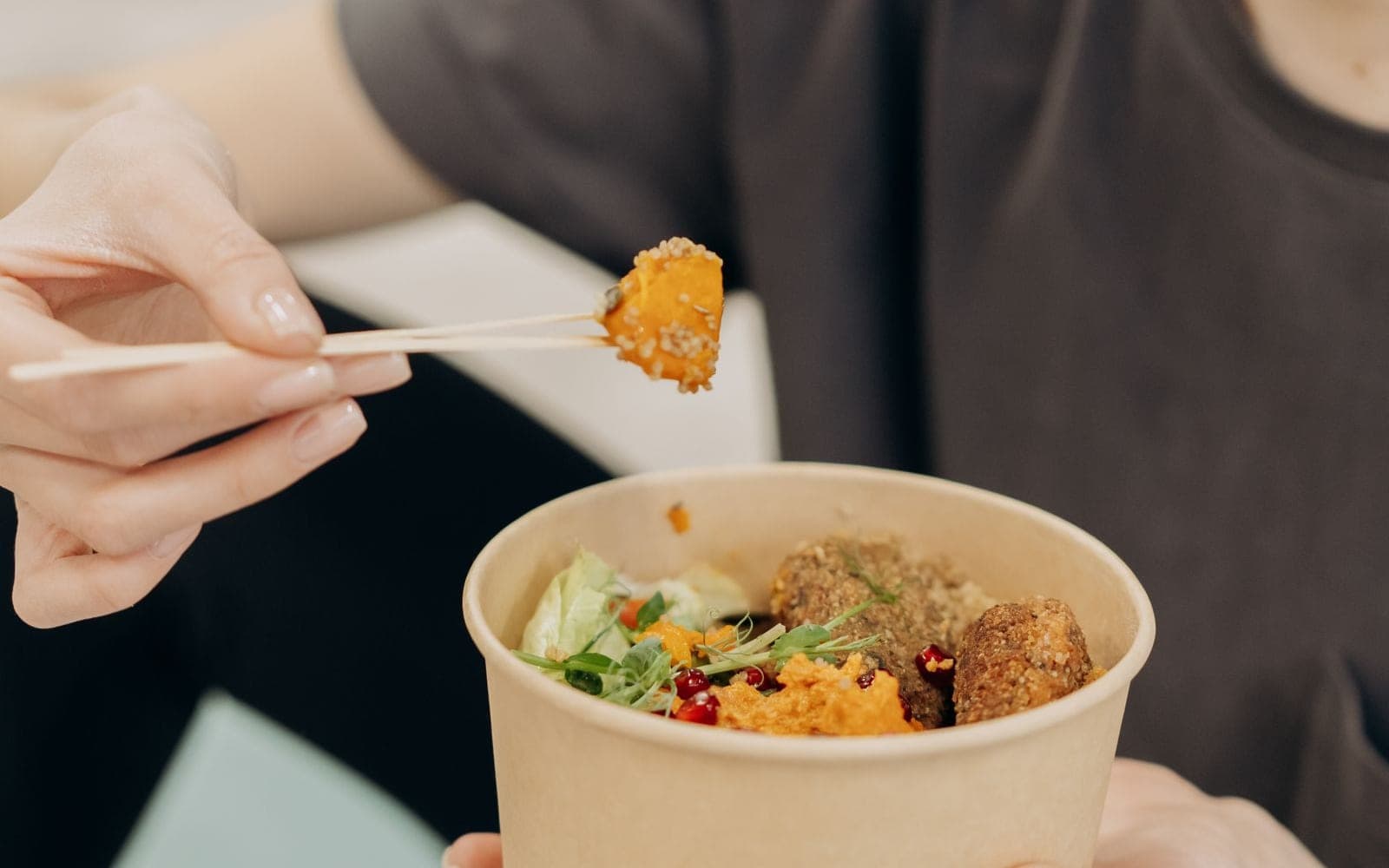 Tigela de papel com salada e grãos servida com um palito