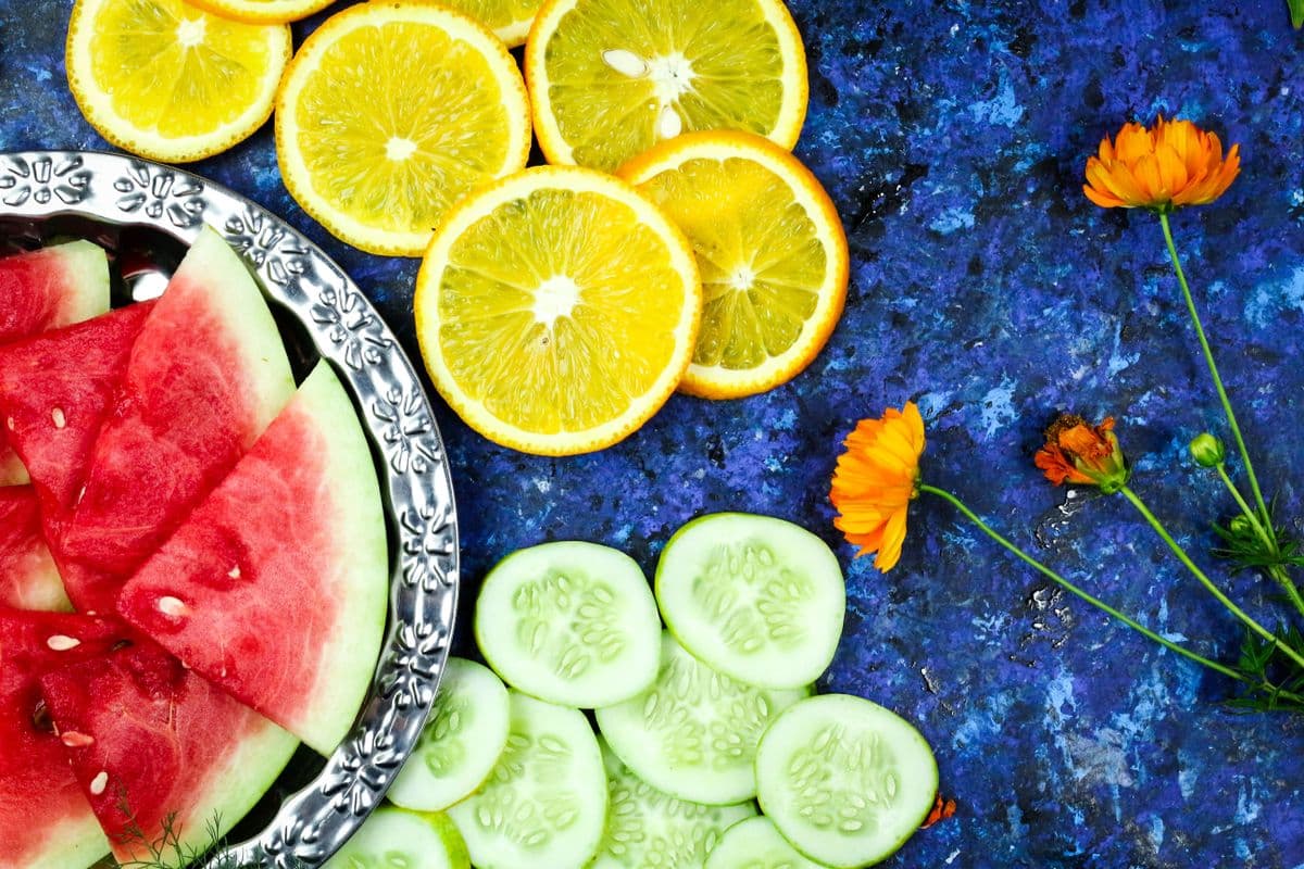 Fatias de melancia, laranja e pepino sobre fundo azul