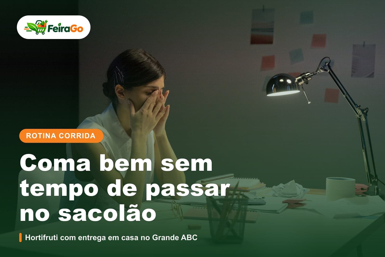 Profissional de blusa branca com as mãos no rosto, cansada, sentada a uma mesa de trabalho com abajur