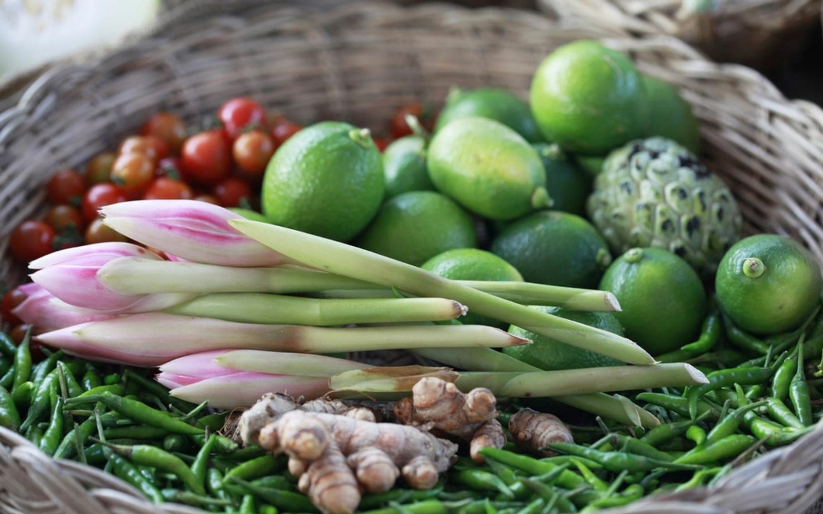 Cesta com limões, ervas, gengibre e pimentas frescas