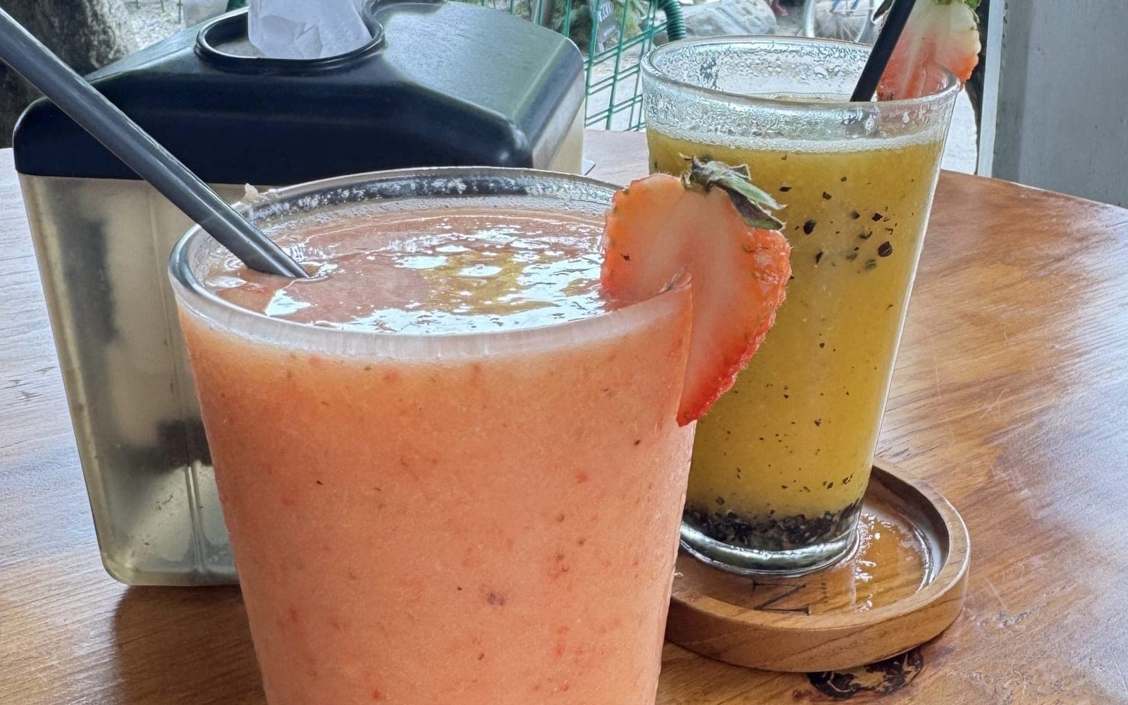 Copo de vitamina rosada sobre uma mesa de madeira