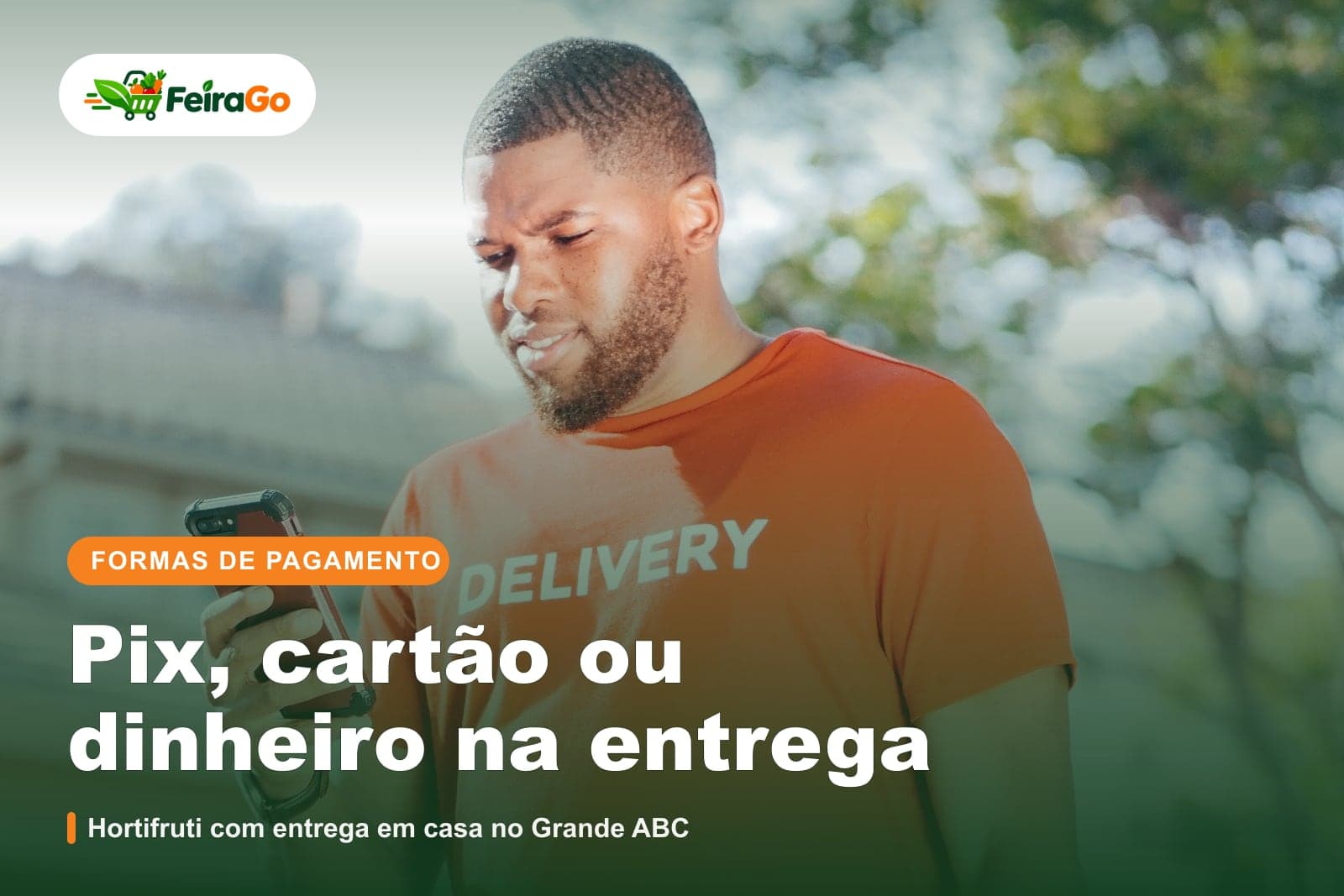 Entregador de camiseta laranja confere o pedido no celular