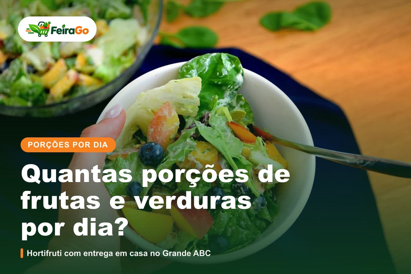 Mão segura uma tigela branca com salada de folhas, frutas e mirtilos
