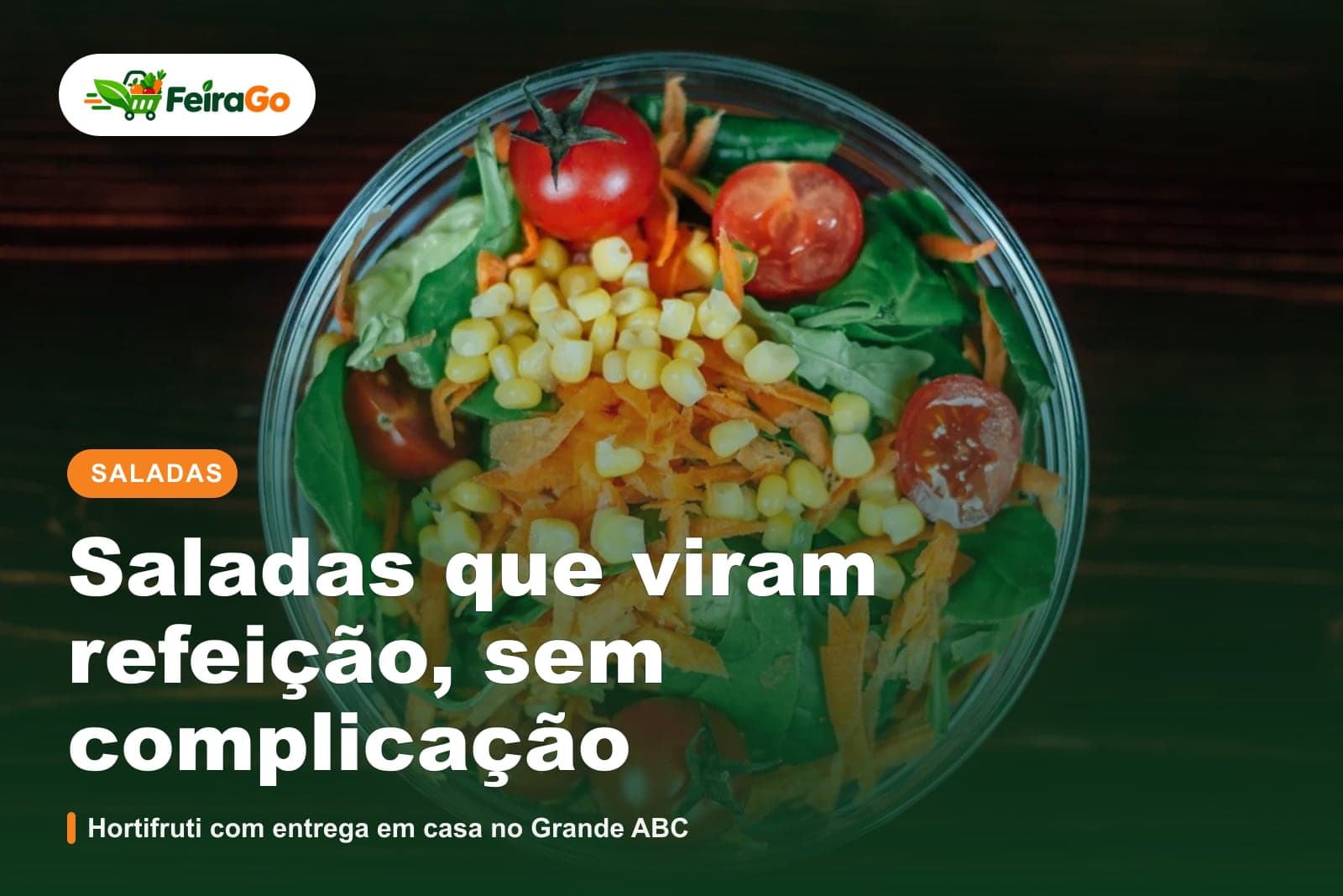 Tigela de vidro vista de cima, com salada de espinafre, tomate, milho e cenoura ralada